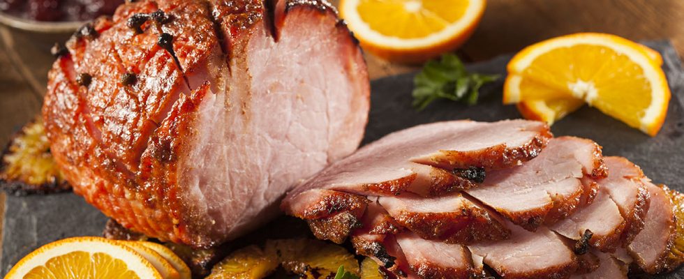 cut ham with oranges on a platter
